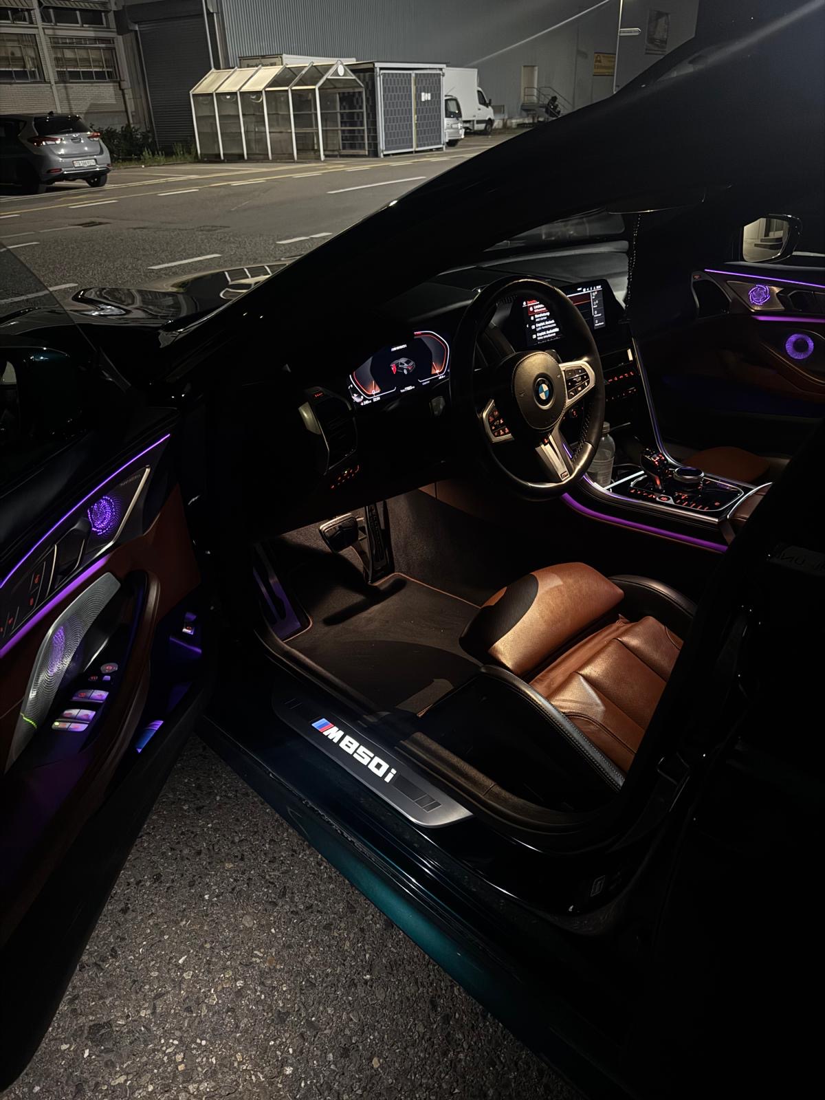 BMW M850i Innenraum in Tartufo Schwarz Individual Volleder bei Nacht mit Ambientebeleuchtung